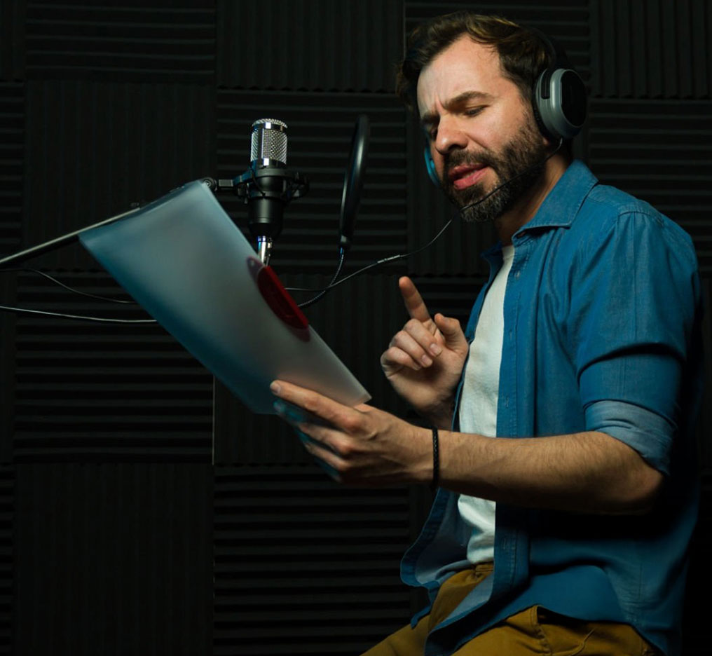 Voice actor recording audiobook narration in professional vocal booth at Somni Studios