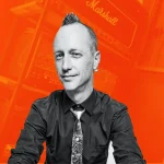 Matthew Fletcher recording and mixing engineer at Somni Studios on orange background portrait