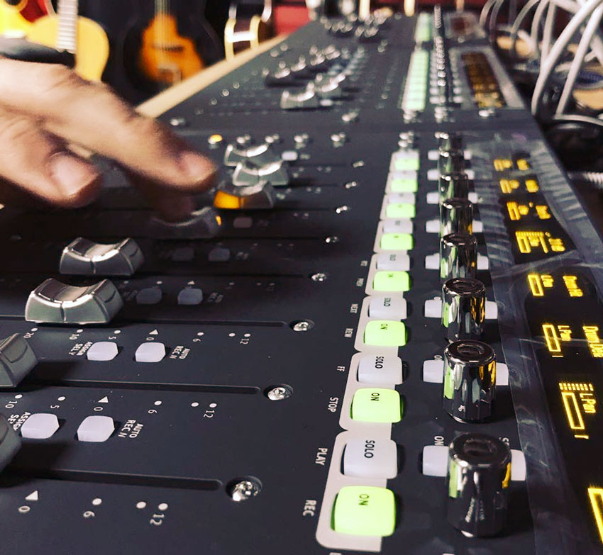 Mixing console with engineer adjusting levels at Somni Studios for professional audio mixing services