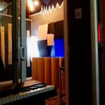 Soundproof vocal booth and control room at Somni Studios with acoustic foam treatment.