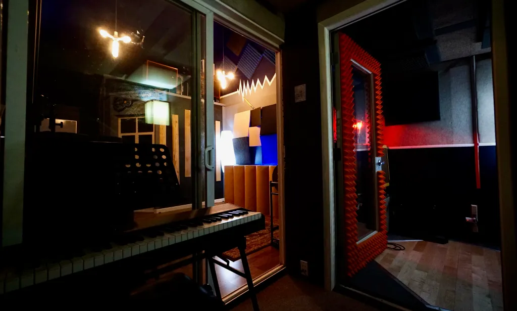 Soundproof vocal booth and control room at Somni Studios with acoustic foam treatment.