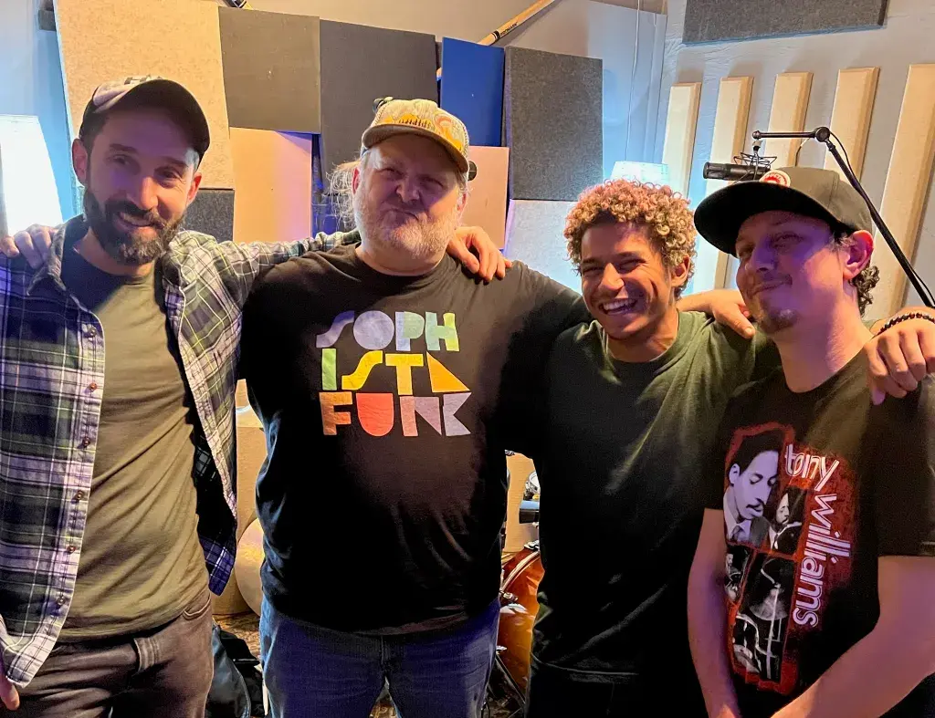 Musicians collaborating at Somni Studios recording session.
