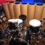 Drum kit setup in SOMNI Studios live recording room with multiple microphones for professional multi-track recording in Central Oregon