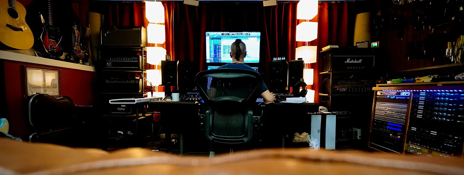 Mixing engineer working at Somni Studios control room surrounded by analog gear.