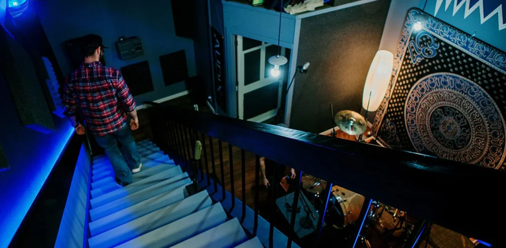 Engineer walking down staircase into recording rooms at SOMNI Studios Central Oregon