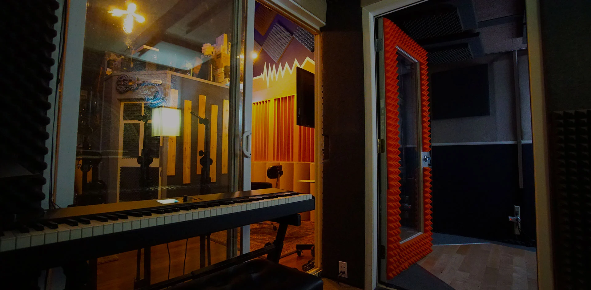 Recording studio with vocal booth, keyboard, and acoustic panels at Somni Studios in Bend, Oregon