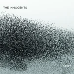 Minimalist cover showing a dense swarm of small black dots resembling a flock of birds, with the text “The Innocents – Drift.”