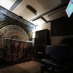 Interior view of the Somni Studios 4 Square Room with acoustic panels and gear.