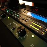 Digital metering display and right-channel mix bus controls glowing in the Somni Studios rack.