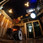 Somni Studios Live Room showing acoustic treatment, lighting, and drum setup.