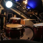 Drum kit perspective in the Somni Studios Live Room with illuminated acoustic panels.