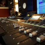 Close-up of faders on the Somni Studios mixing console during a session.