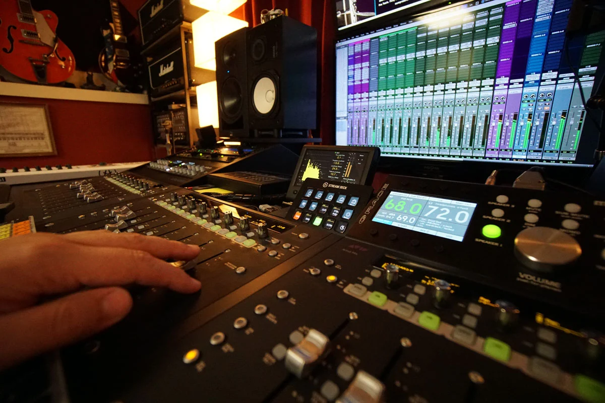 Audio engineer Scott Baber adjusting faders on the mixing console at Somni Studios.