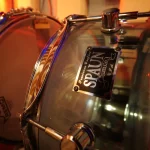 Close-up of a Spaun acrylic snare drum with reflective chrome hardware at Somni Studios.